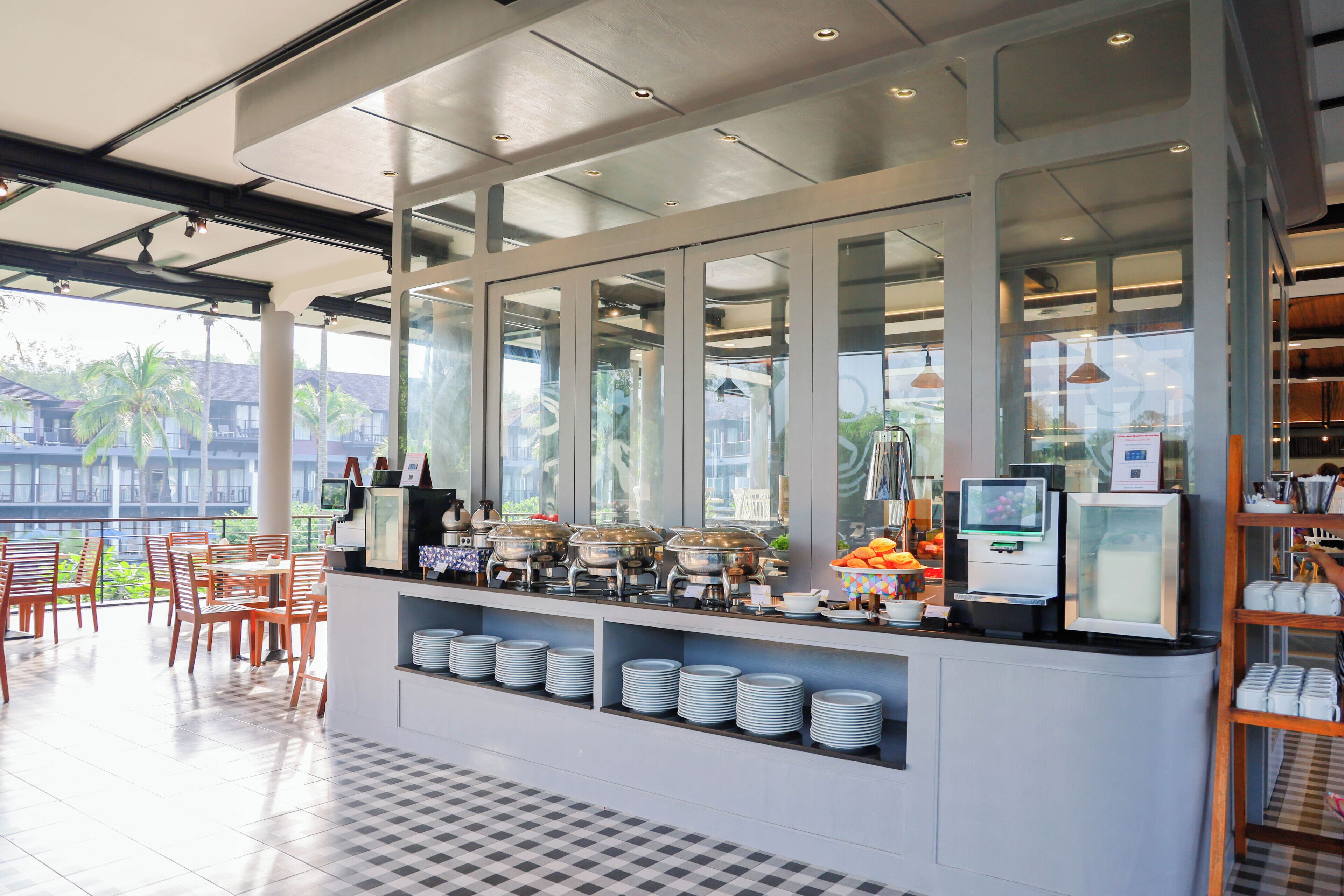 Un área de buffet con mostrador, platos y recipientes para comida.