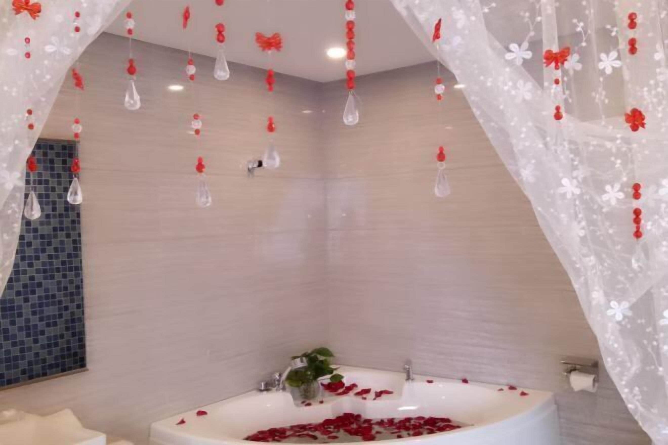 A modern bathroom with a freestanding bathtub, a glass shower enclosure, and a tiled wall.