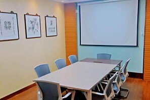 A conference room with a long table, six chairs, and a projector screen on the wall. - JT Days Hotel (Changchun)