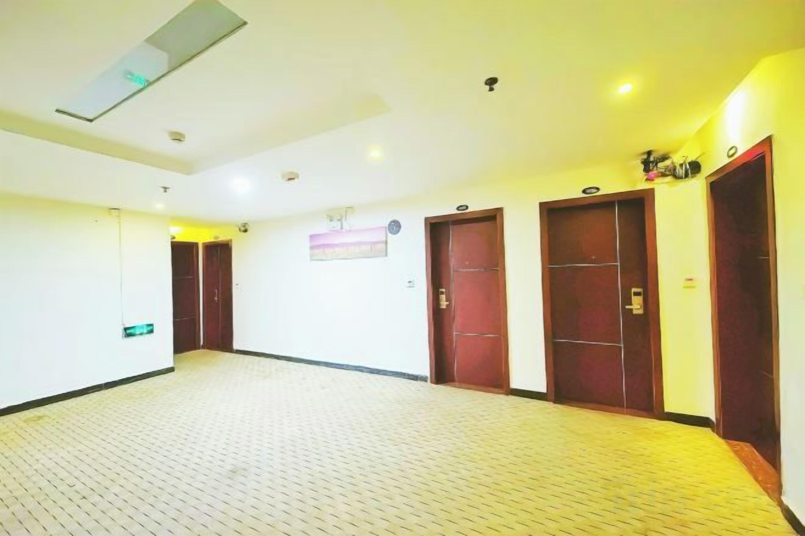 Un couloir avec un sol carrelé, des portes en bois et un luminaire au plafond.