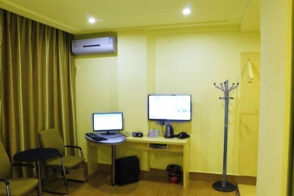A hotel room with two desks, two computers, a coat rack, and a window with curtains. - Xinju Express Hotel (Hezhou)