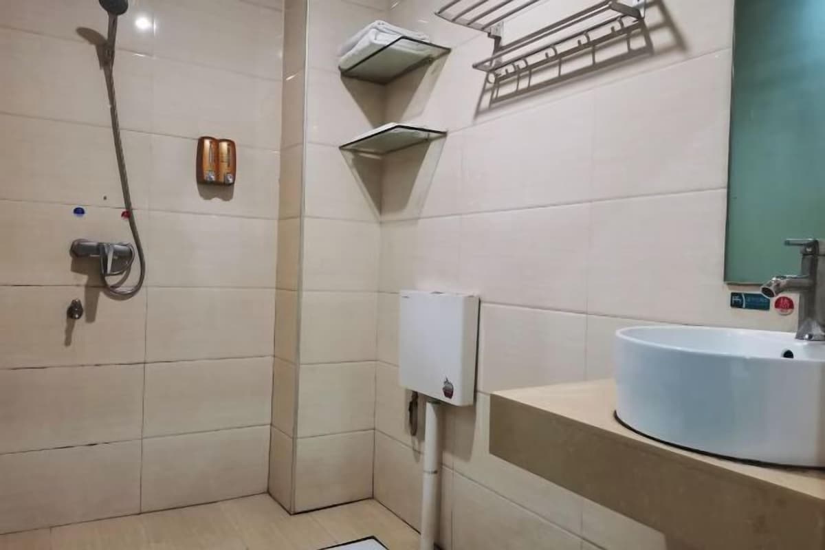 A bathroom with a shower, a sink, and a hand dryer.