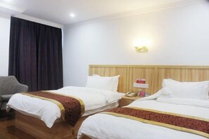 A hotel room with two beds, a wooden headboard, a bedside table with a phone, and a chair. - Lihuang Hotel (Jiaxing)