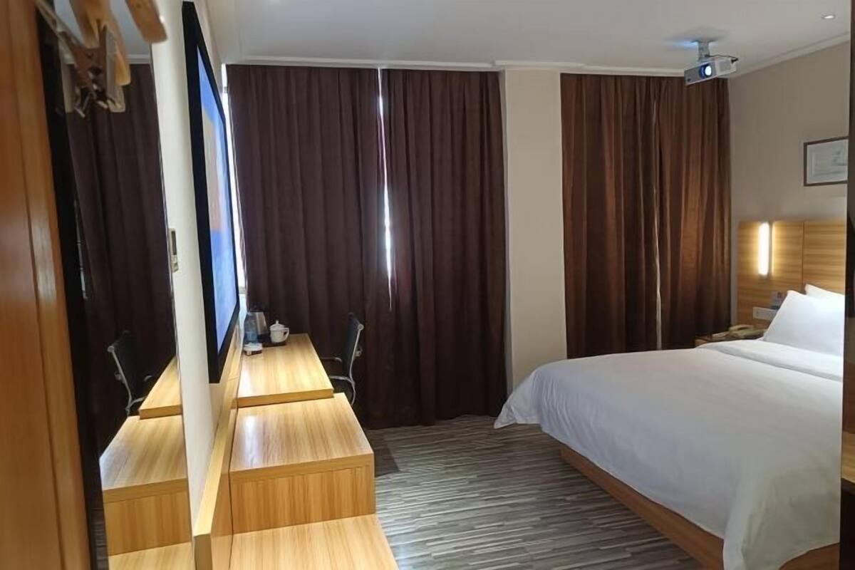 Ein Hotelzimmer mit einem Bett, einem Schreibtisch und einem Fernseher.