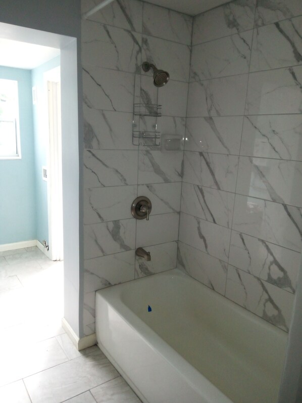 A bathroom with a bathtub, a shower, and a toilet.