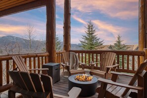 A wooden deck with Adirondack chairs, a fire pit, and a view of mountains. - High Meadow by AvantStay | Alpine Views w/ Indoor Pool,Hot Tub & Open Floor Plan (Park City)
