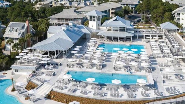 An aerial view of a resort with multiple swimming pools, sun loungers, and covered areas. - WaterColor-Santa Rosa.  Golf Cart, 2 min from beach, Community Pools (Santa Rosa Beach)