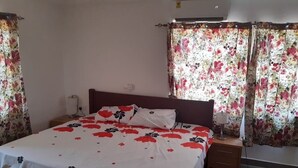 A bedroom with a bed, nightstands, and curtains.