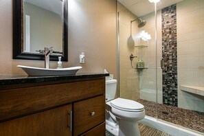 Een bad/douchecombinatie, een haardroger, handdoeken, zeep