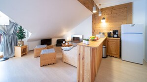 Eine moderne Loft-Wohnung mit Küche, Wohnbereich und kleinem Balkon.