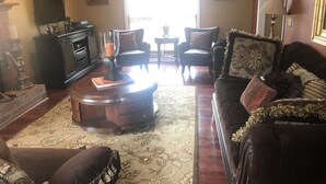 A living room with a fireplace, two armchairs, a sofa, and a coffee table. - Welcome Home!! (Marietta)