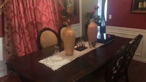 A dining table with a lace tablecloth, two vases, and wine glasses. - Welcome Home!! (Marietta)