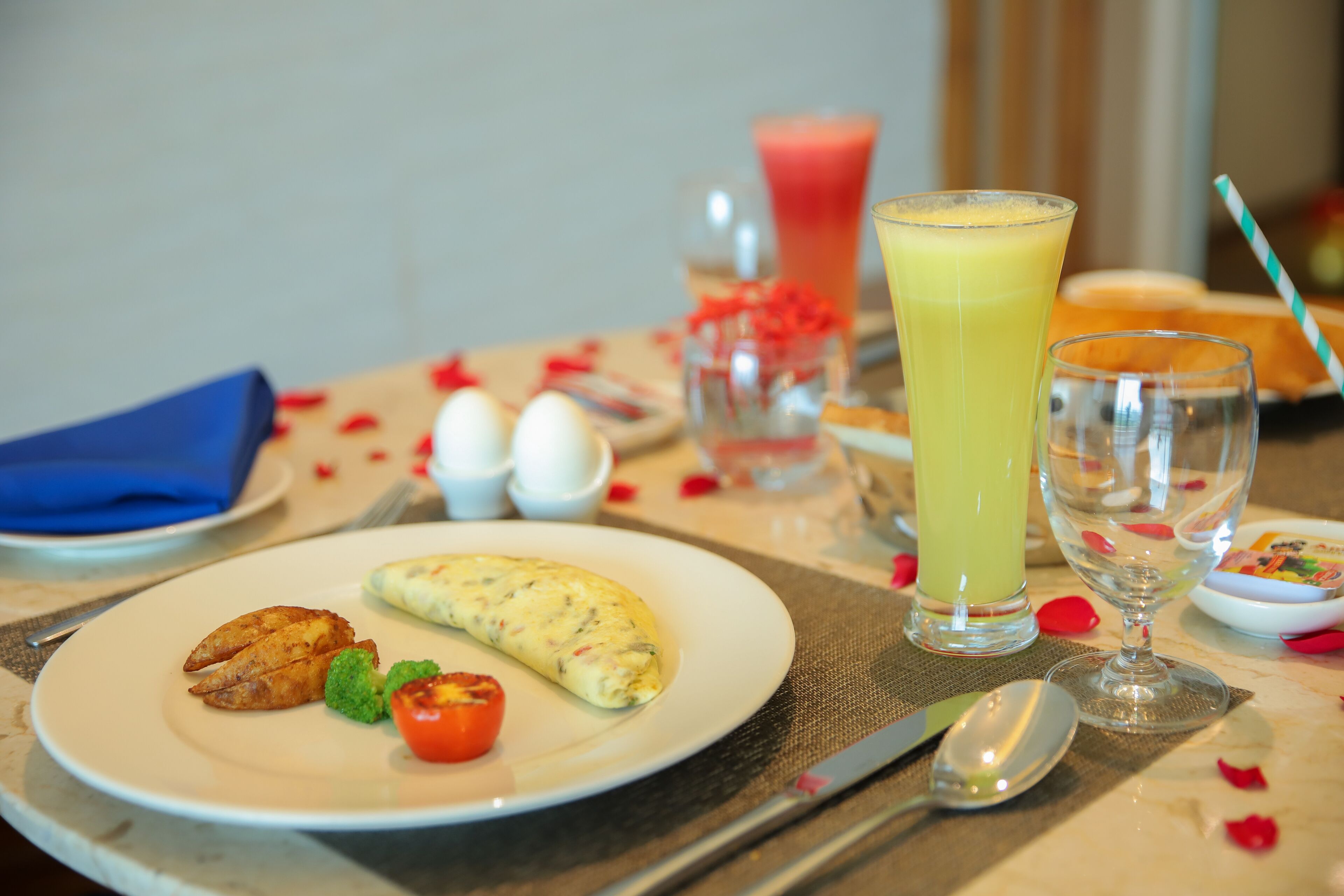 A breakfast setting with an omelette, toast, and a glass of orange juice on a table.