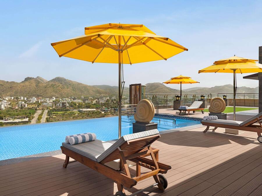 Een buitenzwembad, ligstoelen bij het zwembad