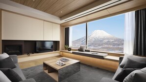Una sala de estar moderna con un ventanal grande, un televisor de pantalla plana y una chimenea.