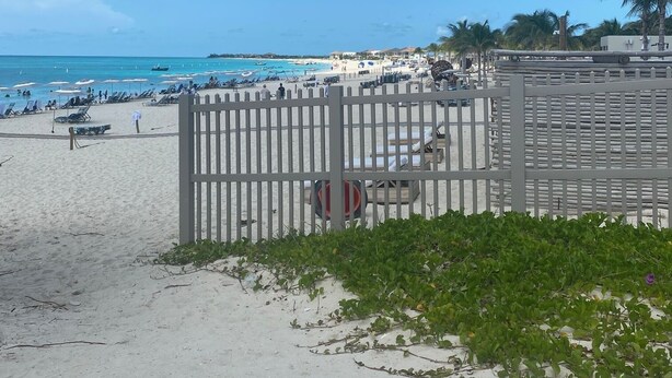 A beach with a wooden fence, a sandy area, and a clear blue sky. - Bimini Home at the Beach (Bimini)
