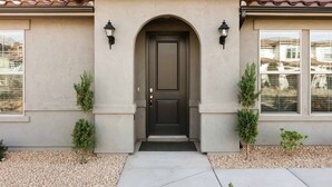 A house with a dark front door, two small trees on either side, and a tiled roof. - Libelle Landing by RedAwning (Washington)