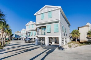 A multi-story residential building with a symmetrical facade, large windows with shutters, and a central entrance.
