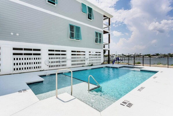 A swimming pool with a white deck, a metal ladder, and a white fence. - The Meadows-Mallory Square North |Community Pool |Mins to Gulf Beaches |Gourmet Kitchen |Boat Dock (Pensacola)