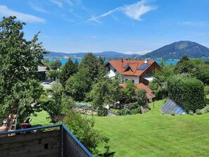 Un quartiere residenziale con case, una montagna e un lago sullo sfondo.