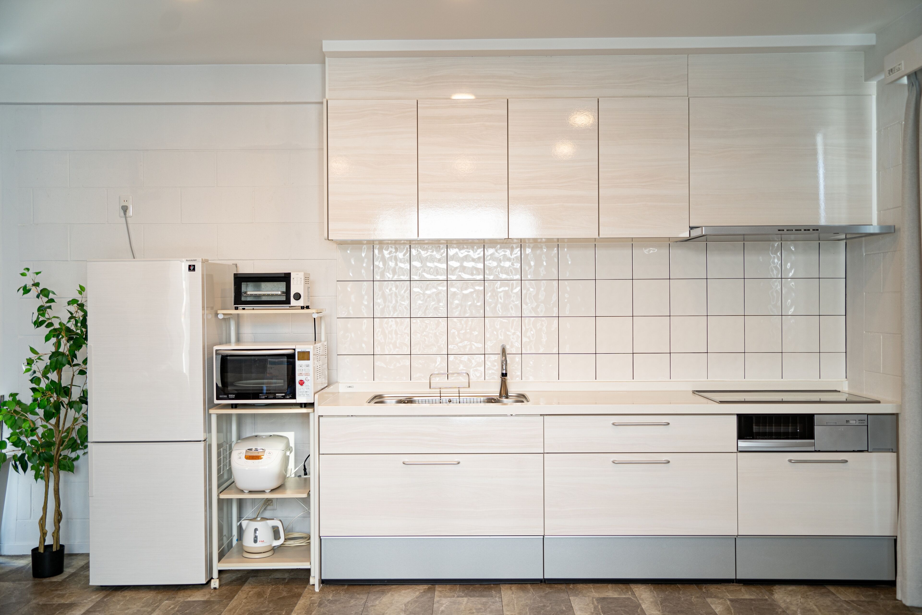 A modern kitchen with white cabinetry, a built-in microwave, a coffee maker, and a dishwasher.