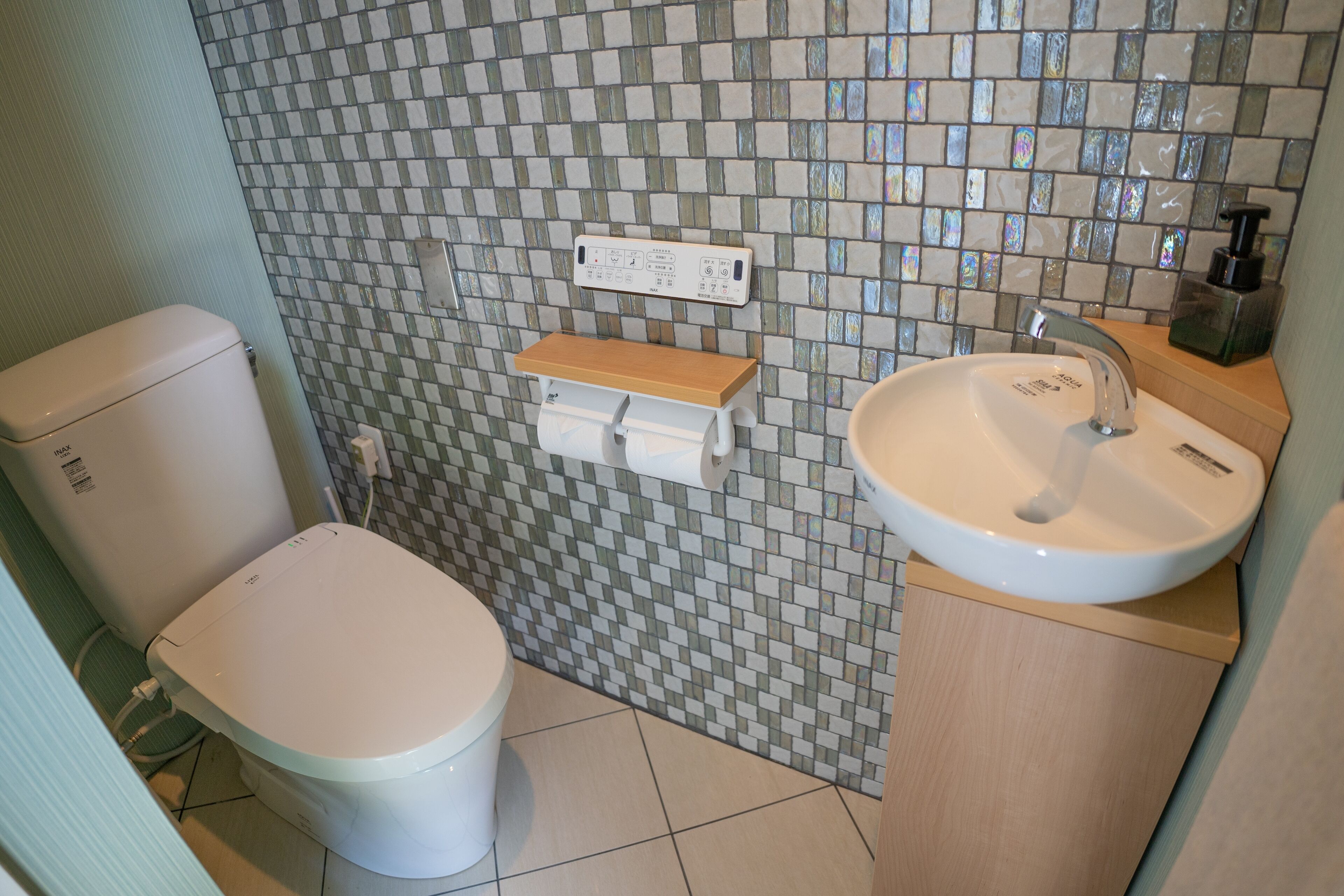 A bathroom with a toilet, a sink, and a mirror.