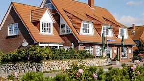 A two-story house with a steeply pitched roof, brick walls, and a stone foundation. - Pure bliss Mandö, Germany (List)