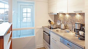 A modern kitchen with a large window, stainless steel appliances, and a tiled backsplash. - Pure bliss Mandö, Germany (List)