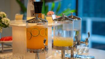 A beverage station with two dispensers, one with a citrus drink and the other with a yellow beverage, both with spouts for pouring.