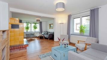 Een moderne woonkamer met een open haard, een bank, een bijzettafeltje en een eethoek.