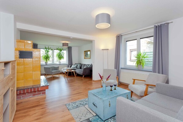 A modern living room with a fireplace, a sofa, a coffee table, and a dining area.