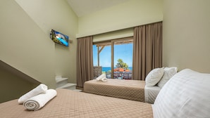 Una camera d'albergo con due letti, una televisione a parete e un balcone vista mare.