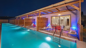 Una piscina con lettini e una zona relax all'ombra.