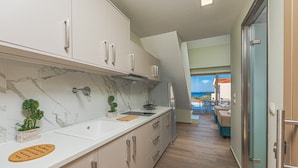 Una cucina moderna con piani di lavoro in marmo, piano cottura integrato e vista sulla zona relax esterna.