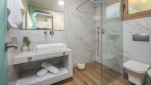 Un bagno moderno con doccia vetro, lavandino bianco e WC.