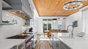 A modern kitchen with a central island, built-in appliances, and a wooden ceiling. - 🐬🐟 The Life Aquatic | Pool | Golf Cart | Rooftop Gulf Views | FREE Excursions ☀️ (Destin)