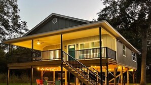 A two-story house with a covered porch and a staircase leading to the upper level. - Brazos River Bungalow - Close To Silos & Baylor (Waco)