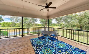 A covered outdoor area with a ceiling fan, a round table with chairs, and a patterned rug. - Brazos River Bungalow - Close To Silos & Baylor (Waco)