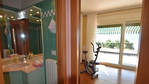 A bathroom with a large mirror, a sink, and a towel rack. There is a window with a view of the outside. - Apartment in Verbania near Lake and Islands (Verbania)