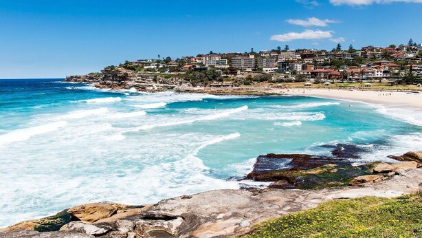 A coastal town with a beach, rocky shoreline, and residential buildings. - Magnificent 3BR Bronte Holiday House with Views (Bronte)