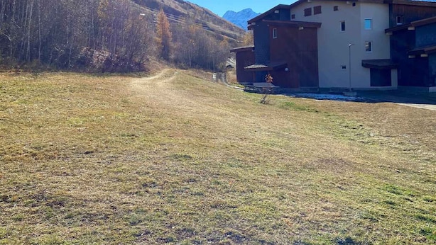 Ein Gebäude mit Flachdach, Garage und einer kleinen Veranda.