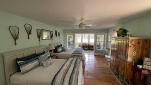 A bedroom with two beds, a ceiling fan, and a wooden cabinet with decorative items. - Single Family Home, Land trans Round Trip! Melrose Pool Open! (Daufuskie Island)