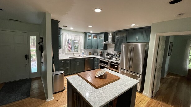 A modern kitchen with dark cabinets, stainless steel appliances, and a central island. - Single Family Home, Land trans Round Trip! Melrose Pool Open! (Daufuskie Island)