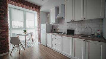 Klassiek appartement | Privékeuken | Een koelkast met diepvriezer, een microgolfoven, een kookplaat