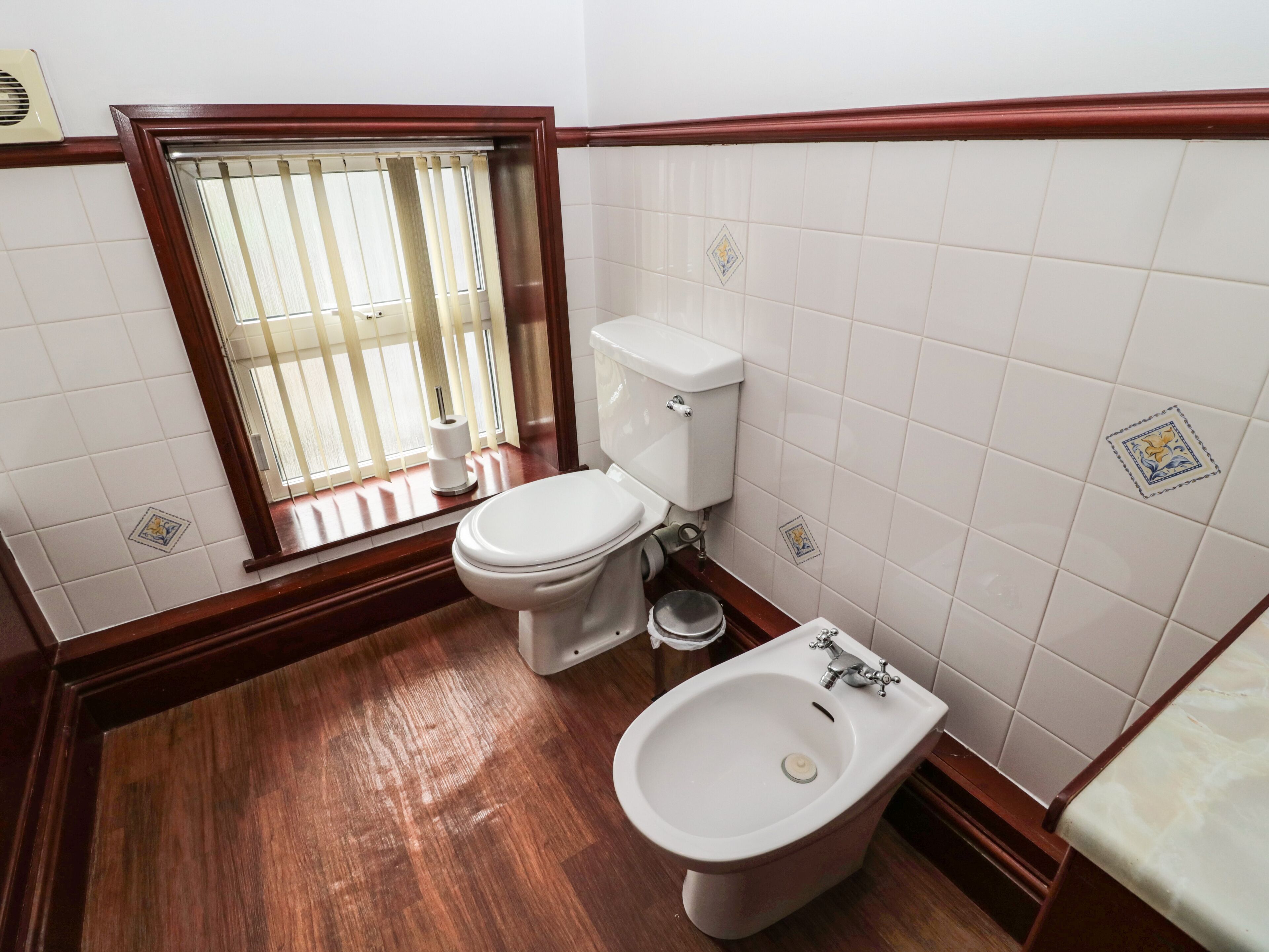 A bathroom with a toilet, bidet, and sink.