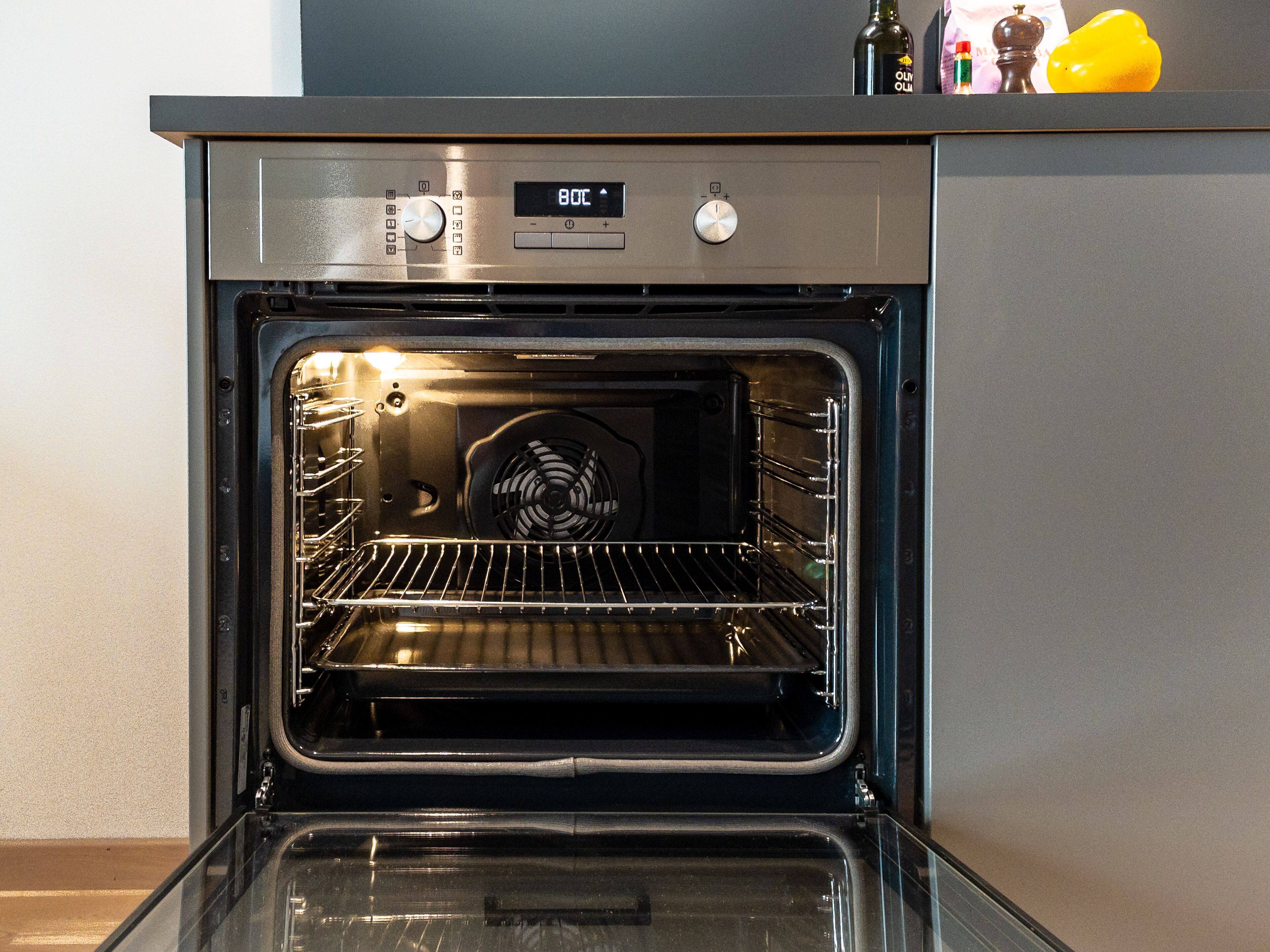 Un horno abierto con pantalla digital, perillas de control y una rejilla en su interior.