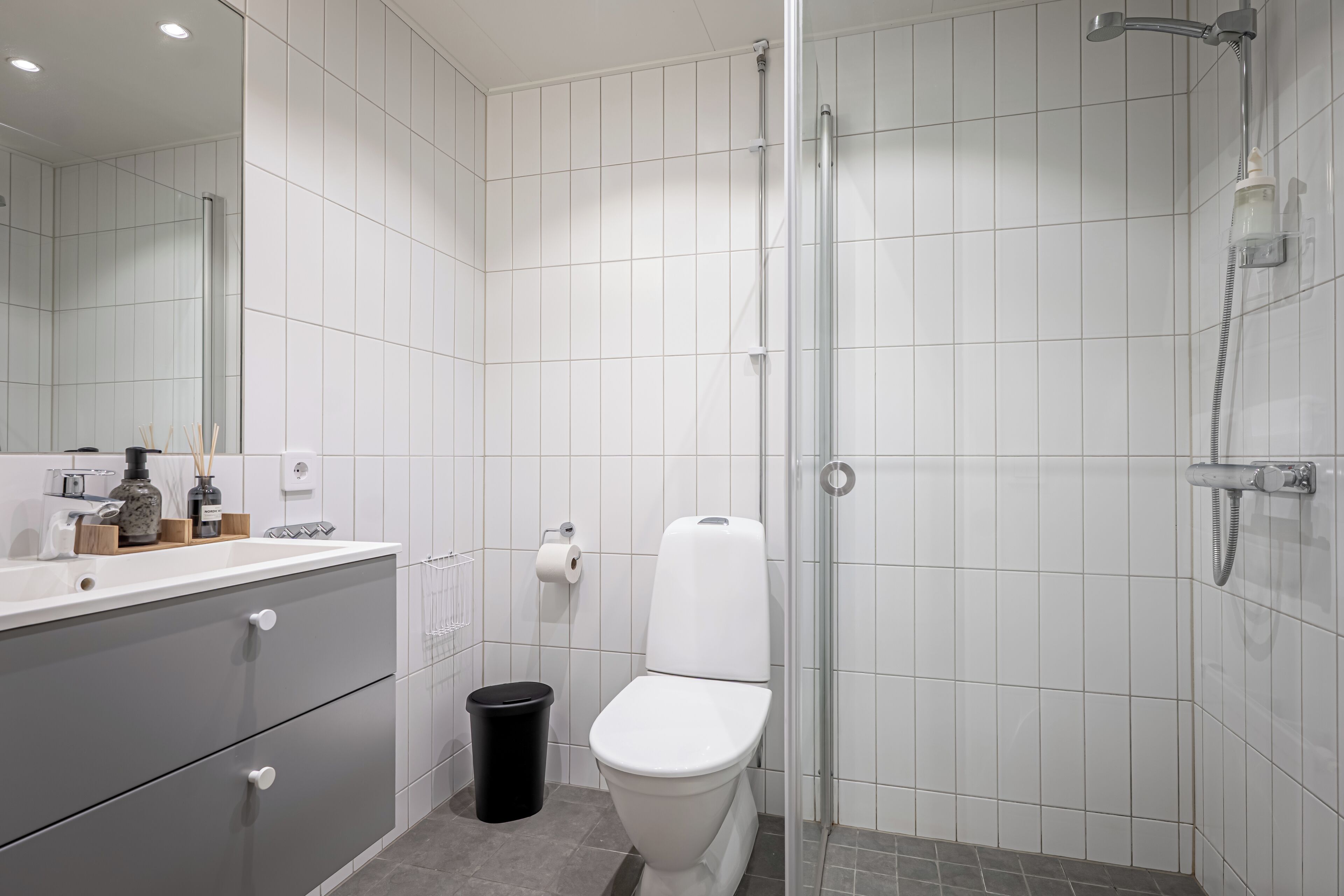 A modern bathroom with a toilet, sink, and shower.