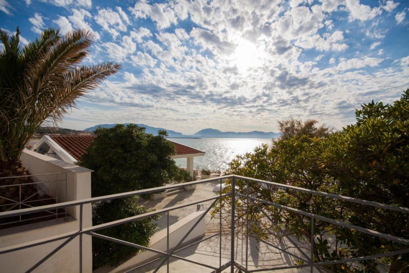 A balcony with a view of the sea and mountains.