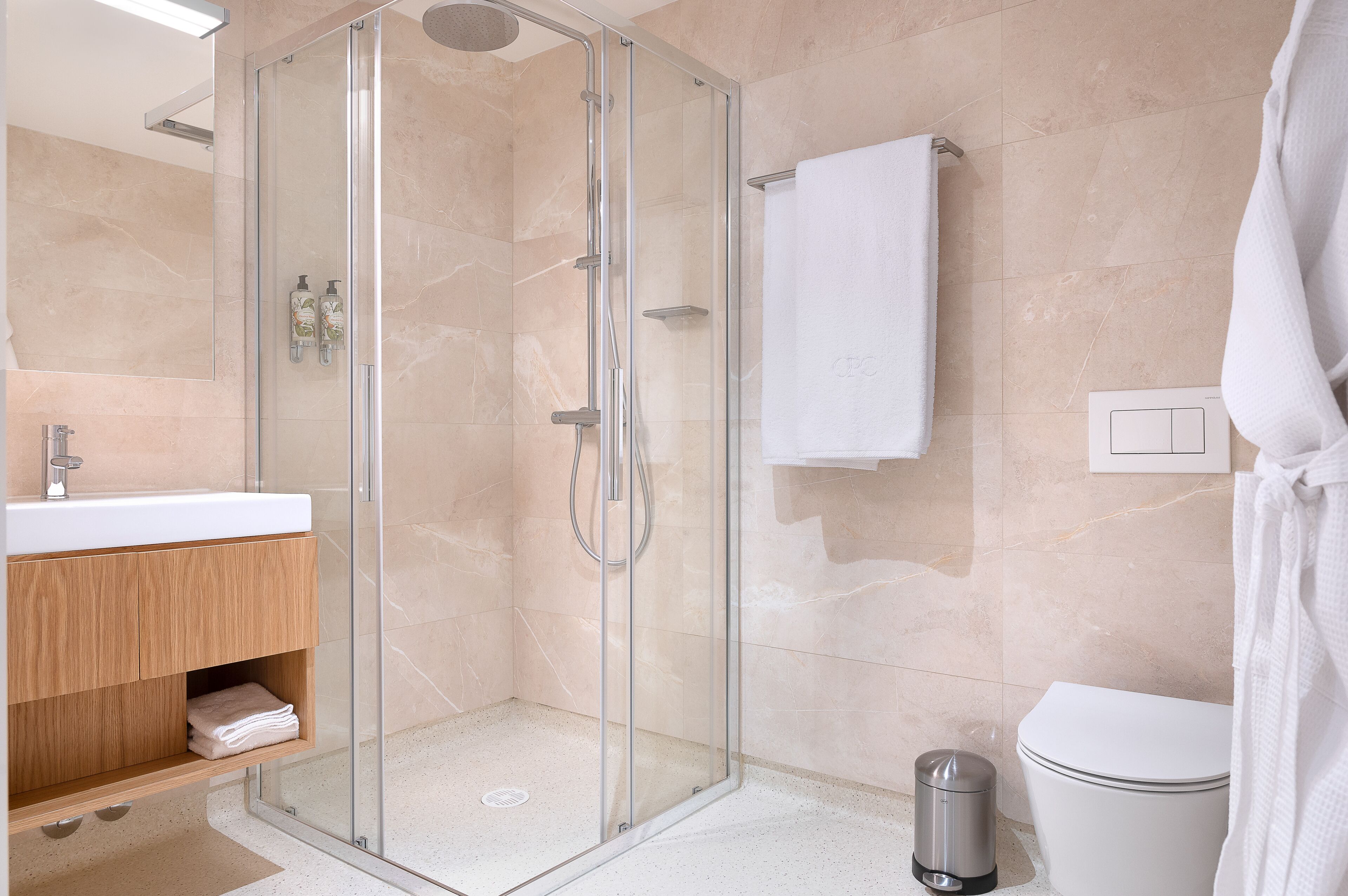 Une salle de bain moderne avec une douche à parois de verre, un lavabo blanc et des toilettes.