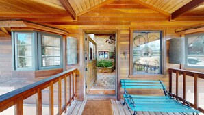 A wooden cabin with a porch, a stone fireplace, and a view of the outdoors. - Views | Pet Friendly | Folley Cabin (Angel Fire)